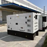 Row of white silent-type generator enclosures with the 20 kW Perkins model in front